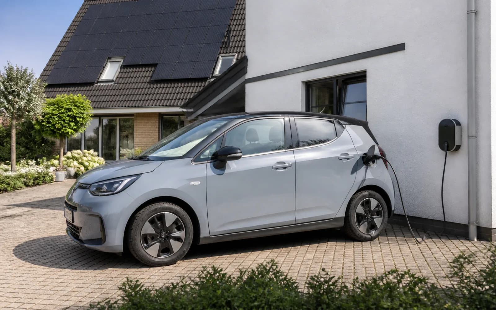 Elektrische auto aan de laadpaal voor een woning met zonnepanelen
