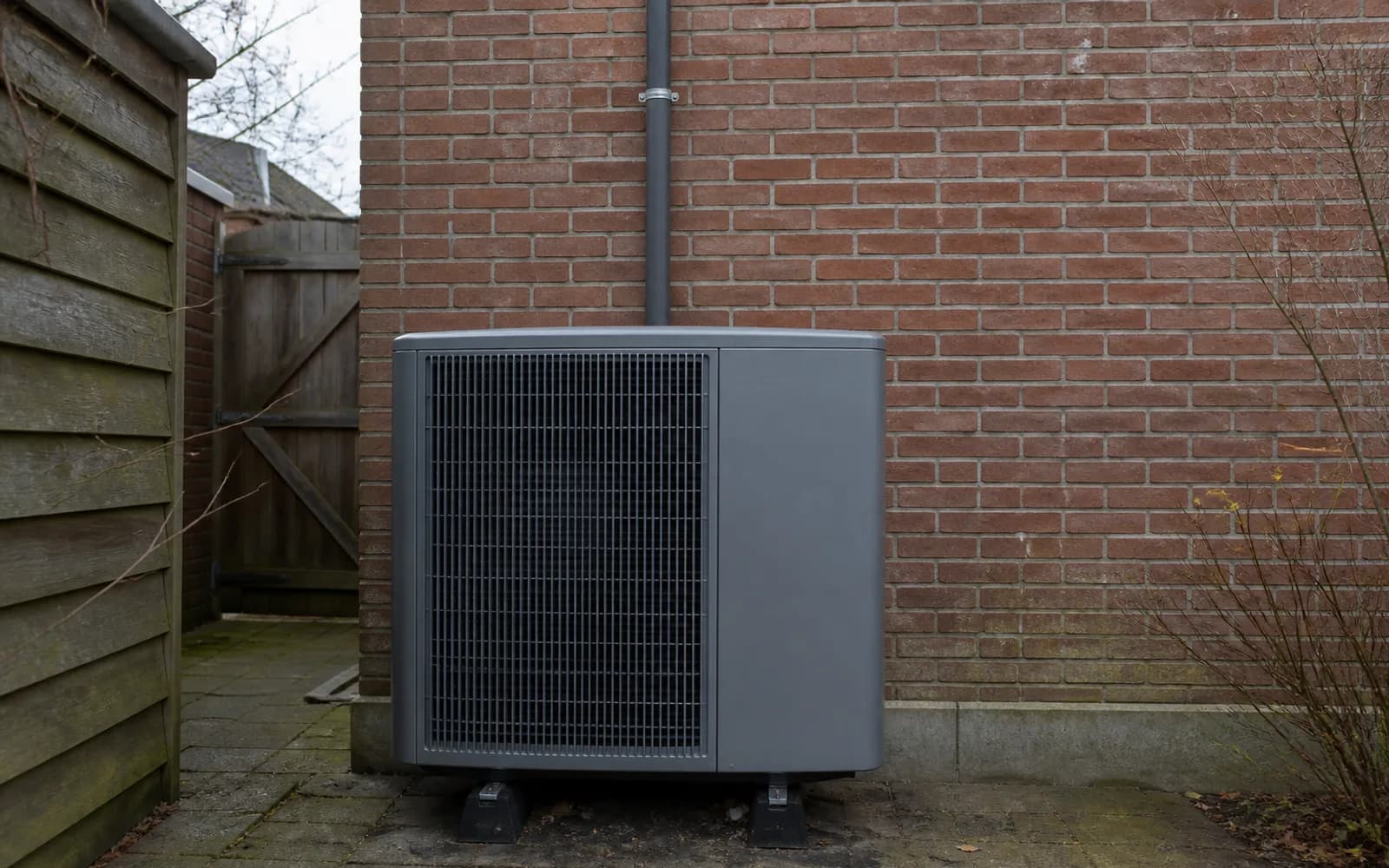 Warmtepomp buitenunit in een smalle Nederlandse achtertuin