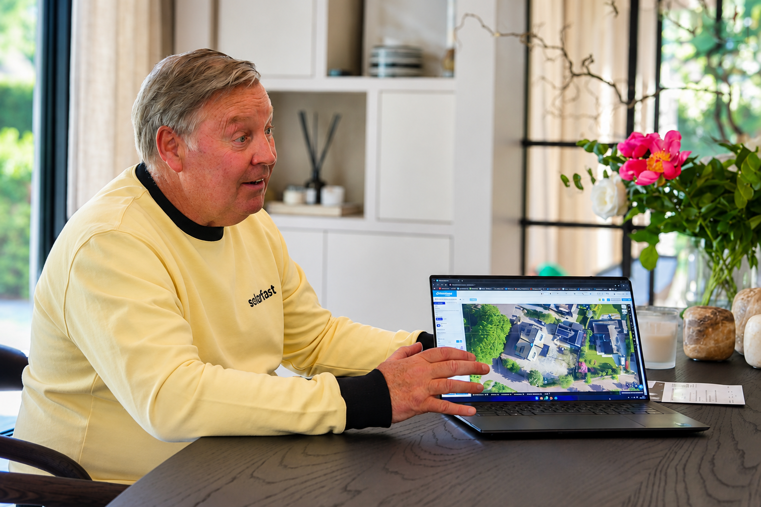 SolarFast-adviseur bespreekt het dakplan op de laptop aan tafel